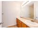 Well-lit bathroom with dual sinks, wood vanity, and a large mirror, designed for comfort and convenience at 15955 E Geddes Dr # 55, Aurora, CO 80016