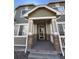 Inviting front porch with stone accents and white railings offers a warm welcome to this charming home at 15955 E Geddes Dr # 55, Aurora, CO 80016