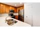 Well-equipped kitchen with stainless steel appliances, light countertops, and warm wood cabinetry at 15955 E Geddes Dr # 55, Aurora, CO 80016