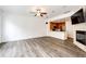 Open living area boasts wood floors, fan, kitchen, and fireplace enhancing a modern, connected living space at 15955 E Geddes Dr # 55, Aurora, CO 80016