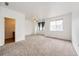 Spacious, naturally lit living room with neutral carpet and ceiling fan, showcasing a welcoming atmosphere at 15955 E Geddes Dr # 55, Aurora, CO 80016