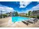 Community pool surrounded by lounge chairs, landscaping, and attractive residential buildings under a vibrant blue sky at 15955 E Geddes Dr # 55, Aurora, CO 80016
