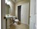 Bathroom featuring a pedestal sink, tiled floors, and a large closet space, designed for comfort and functionality at 4519 S Atchison Way, Aurora, CO 80015