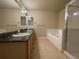 Well-lit primary bathroom featuring dual sinks with granite countertop, walk-in shower, and soaking tub at 4519 S Atchison Way, Aurora, CO 80015