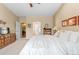 Bright bedroom with white bedding, a ceiling fan, and views into the bathroom at 1410 Exquisite St, Castle Rock, CO 80109