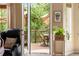 View from inside of the home to a covered patio seating area surrounded by nature at 1410 Exquisite St, Castle Rock, CO 80109