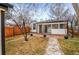 Charming backyard with a small patio, grassy area, and mature trees at 2020 Gray St, Edgewater, CO 80214