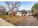 Front yard featuring a well-maintained lawn and driveway leading to a detached garage at 2020 Gray St, Edgewater, CO 80214