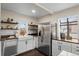 Bright kitchen with white cabinets, stainless steel appliances, and open shelving at 2020 Gray St, Edgewater, CO 80214