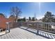 Inviting back deck with wood railings and beautiful views of the backyard and surrounding trees under a bright sky at 11404 E Yale Pl, Aurora, CO 80014