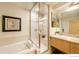 Bright bathroom features a shower with glass door, tub, and marble countertop with a sink at 1401 Wewatta St # 714, Denver, CO 80202