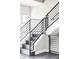 Modern staircase with black metal railings and wood steps, offering a sleek design element to the home at 5036 S Platte River Pkwy, Littleton, CO 80123