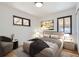 Cozy bedroom featuring a comfortable bed, stylish decor, and natural light from two windows at 10600 E 25Th Ave, Aurora, CO 80010