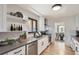 Modern kitchen featuring white cabinets, stainless steel appliances, open shelving and hardwood floors at 10600 E 25Th Ave, Aurora, CO 80010