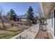 Backyard with stone patio, lush green lawn and tall trees at 9526 E Lake Ave, Greenwood Village, CO 80111