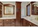 Stylish bathroom featuring dual sinks with marble countertops, wood cabinetry, and a large decorative mirror at 9526 E Lake Ave, Greenwood Village, CO 80111