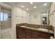 Bright bathroom with double sink vanity, granite countertop, dark wood cabinets, and tiled shower/tub, blending style and functionality at 9526 E Lake Ave, Greenwood Village, CO 80111