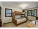 Inviting bedroom featuring a rustic bunk bed, dual windows, and neutral colors, offering a cozy and functional space at 9526 E Lake Ave, Greenwood Village, CO 80111