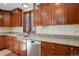 Kitchen featuring cherry cabinets, granite countertops, stainless steel appliances, and natural light at 9526 E Lake Ave, Greenwood Village, CO 80111