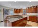 Open kitchen featuring a central island cooktop, granite countertops, wood cabinets and stainless appliances at 9526 E Lake Ave, Greenwood Village, CO 80111