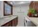 Functional laundry room with granite countertop, ample counter space, washer, and dryer, designed for convenience and efficiency at 9526 E Lake Ave, Greenwood Village, CO 80111