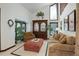 Cozy living room with tall windows, a display cabinet, and comfortable seating, bathed in natural light at 9526 E Lake Ave, Greenwood Village, CO 80111
