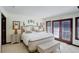 Spacious main bedroom with a large bed, an ensuite bath, and ample natural light from the french doors at 9526 E Lake Ave, Greenwood Village, CO 80111
