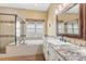 Bathroom featuring a soaking tub, walk-in shower, and vanity with granite countertops at 3967 Eastout Ave, Parker, CO 80138
