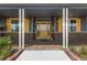 Inviting front entrance with a decorative yellow door and brick accents leading to a cozy porch at 3967 Eastout Ave, Parker, CO 80138