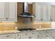 Modern kitchen with granite countertops, stainless appliances, and a brick backsplash over the stove at 3967 Eastout Ave, Parker, CO 80138