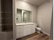 Modern bathroom with vanity, commode, large mirror, wood-look floor, and tiled shower at 48245 Shetland Dr, Bennett, CO 80102