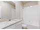 Bright bathroom featuring a tub with white tile surround, large mirror, and quartz countertop at 48245 Shetland Dr, Bennett, CO 80102