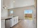 Open kitchen area with white cabinets, a dishwasher, and sliding glass doors leading to the backyard at 48245 Shetland Dr, Bennett, CO 80102