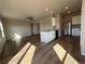 Open-concept kitchen featuring white cabinetry, stainless steel appliances, and eat-in island at 48245 Shetland Dr, Bennett, CO 80102