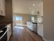 Bright kitchen featuring white cabinetry, hardwood floors, and a sliding glass door to the backyard at 48245 Shetland Dr, Bennett, CO 80102