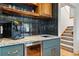Stylish bar area with a beverage refrigerator, sink, granite countertop and floating wood shelves at 6388 Donner Cir, Parker, CO 80134