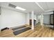 Spacious basement with wooden floors, white walls, and pillars; used as a flex space, featuring yoga mats at 6388 Donner Cir, Parker, CO 80134