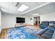 Finished basement with a large blue rug, comfortable seating, and a large screen television at 6388 Donner Cir, Parker, CO 80134
