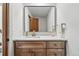Stylish bathroom with a modern vanity and a decorative mirror with patterned wall behind it at 6388 Donner Cir, Parker, CO 80134