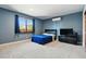 Bedroom featuring a window with dark curtains, neutral carpet, AC unit, and a mounted TV for entertainment at 6388 Donner Cir, Parker, CO 80134
