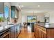 Bright kitchen with stainless appliances, hardwood floors, kitchen island, and a view to the outside at 6388 Donner Cir, Parker, CO 80134