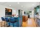 Modern kitchen with breakfast bar, stainless steel appliances, granite countertops, and wood accents at 6388 Donner Cir, Parker, CO 80134