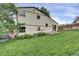 Spacious backyard featuring a lush green lawn, mature trees, and a cozy patio area at 4483 S Eagle Cir, Aurora, CO 80015