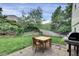 Backyard patio with a wood table set on a stone surface and grassy, green space at 4483 S Eagle Cir, Aurora, CO 80015