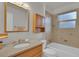 Bathroom featuring granite countertops, wooden cabinetry, a large mirror, and a tiled shower and tub combo at 4483 S Eagle Cir, Aurora, CO 80015
