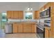 Well-lit kitchen featuring stainless steel appliances, granite countertops, wooden cabinets and backyard view at 4483 S Eagle Cir, Aurora, CO 80015