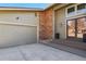 Close-up of the front entry and garage with a brick accent and modern lighting at 6866 W David Ave, Littleton, CO 80128