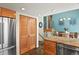 Modern kitchen featuring stainless appliances, wood cabinets, and a staircase to the dining area at 6866 W David Ave, Littleton, CO 80128