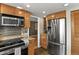 Kitchen featuring stainless steel appliances, wood cabinets and view to other rooms at 6866 W David Ave, Littleton, CO 80128