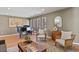 Sunlit living room featuring wood floors, a grand piano, and neutral decor at 6866 W David Ave, Littleton, CO 80128